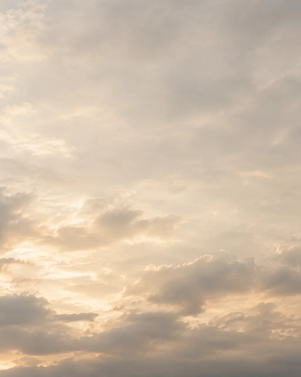 A pale morning sky over soft clouds