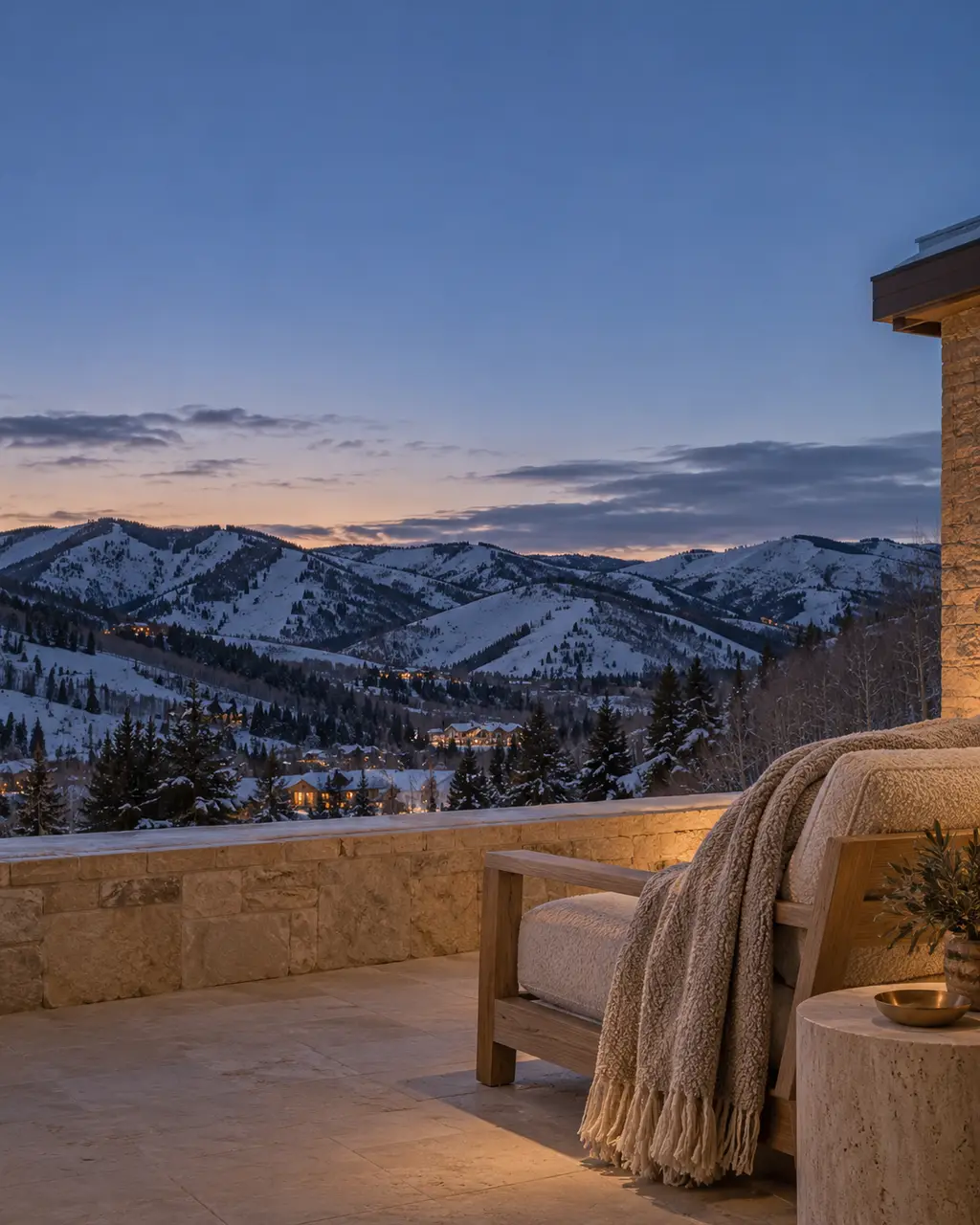 A stone terrace at blue hour with snow on the ridgeline